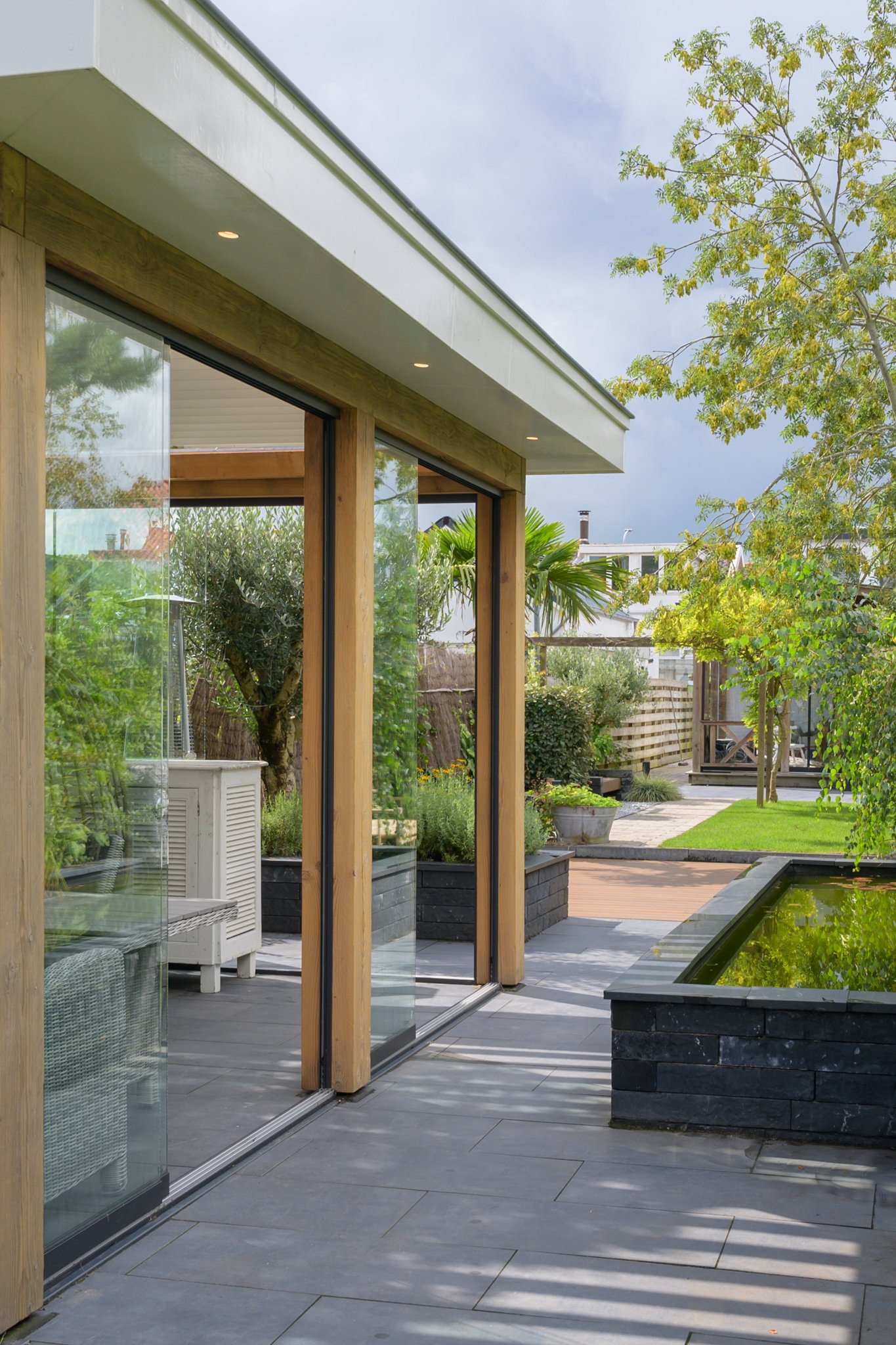 Tuinkamer-hout-aluminium-lamellen-glazen-schuifwanden