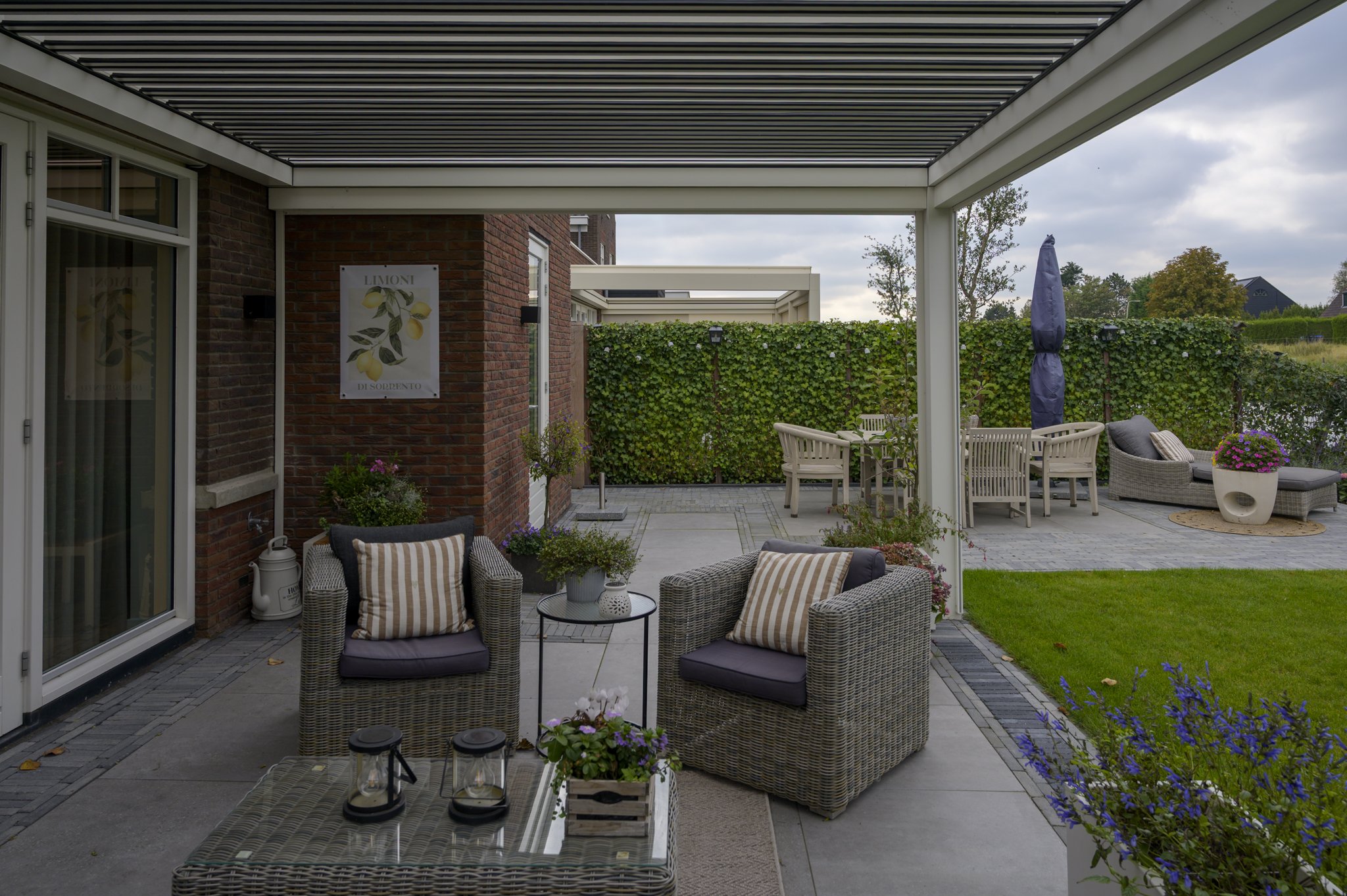 ALYA CORNELS Elite serie terrasoverkapping met kantelbare lamellen aan de gevel van woning