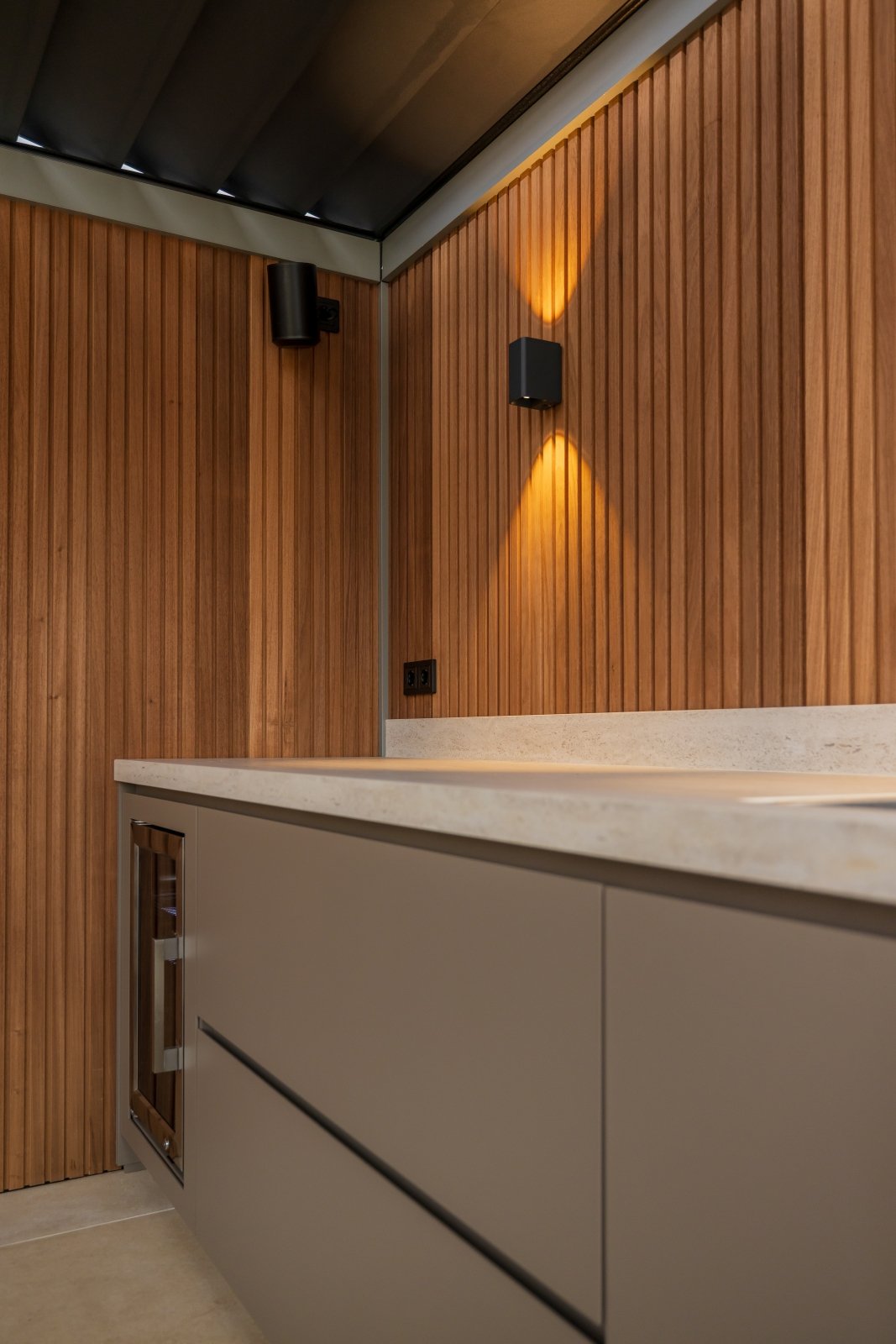 Luxe tuinkamer met buitenkeuken onder lamellen overkapping