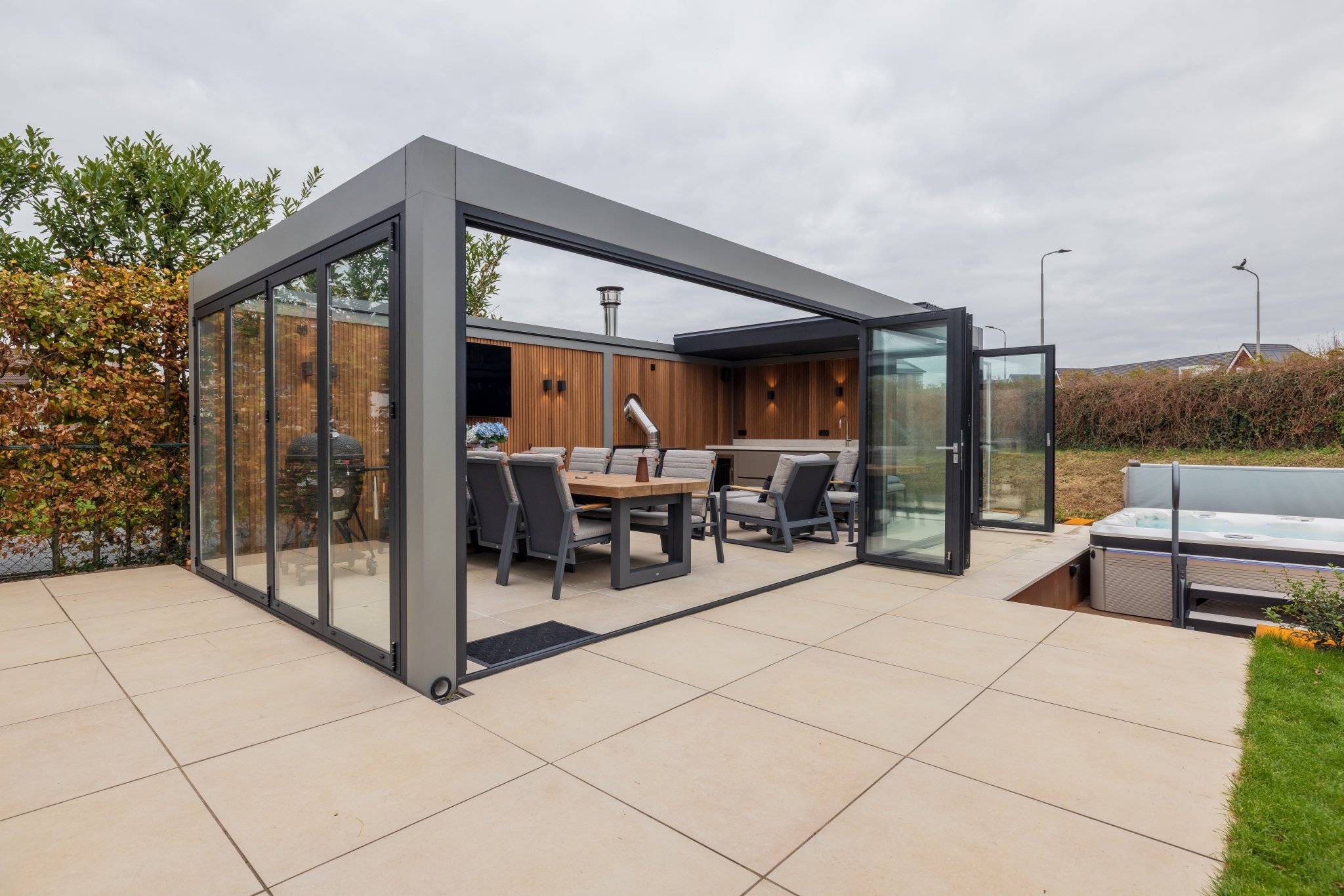 Complete luxe tuinkamer met lamellen overkapping en glazen vouwwand particulier project