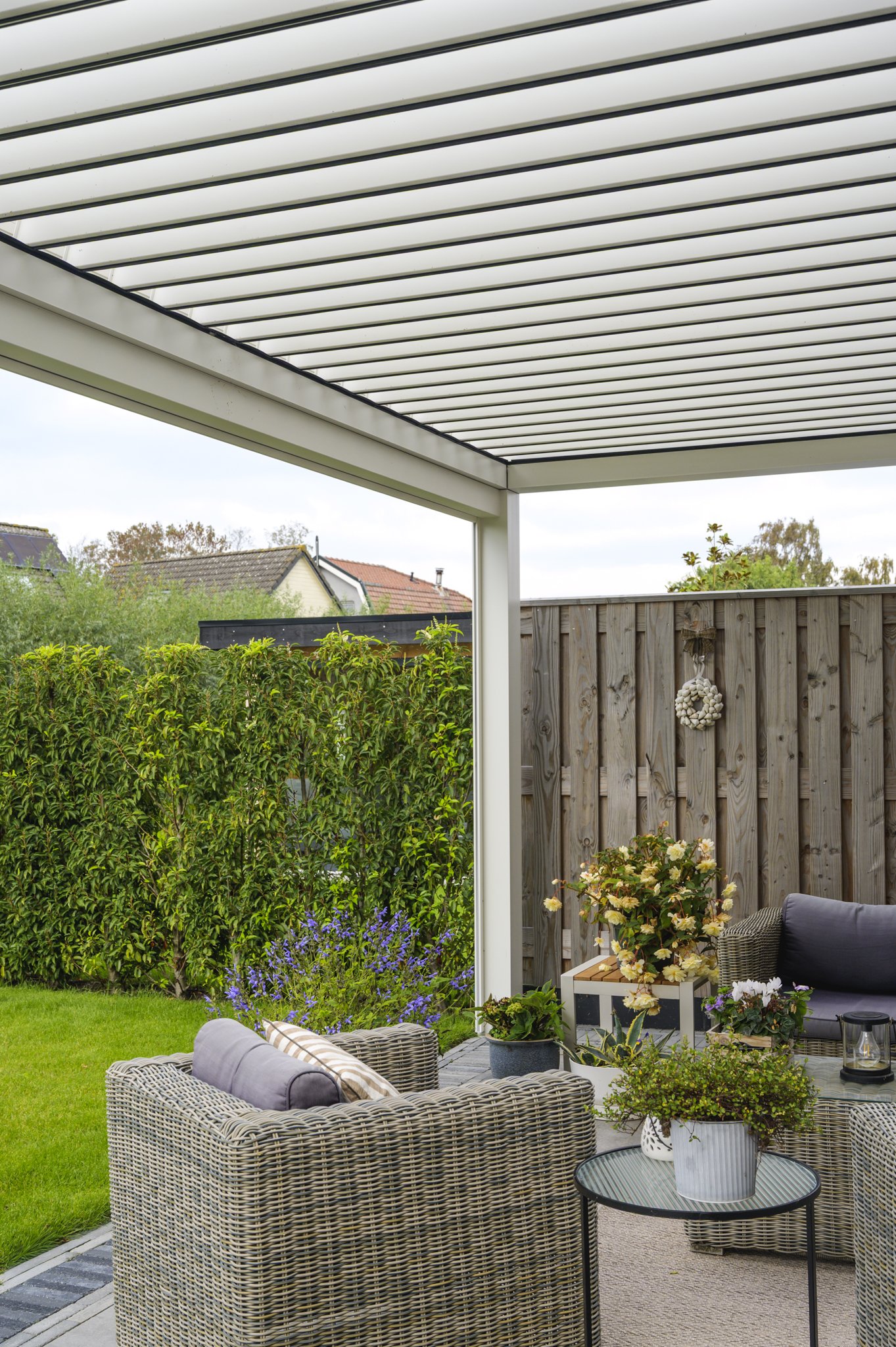 Terras aan gevel van de woning met lamellen overkapping